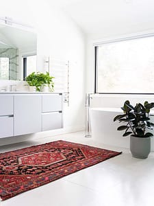 Image de salle de bain très lumineuse avec une fenêtre et les murs peints en blanc